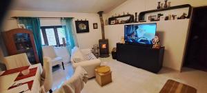 un soggiorno con una TV a schermo piatto su un supporto di Casa Clementina Guest house 