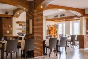 una sala da pranzo con tavoli, sedie e un muro di mattoni di Bernsteinsee Hotel&Ferien a Sassenburg