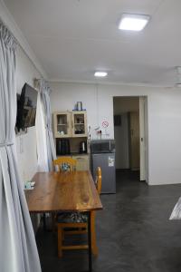 a dining room with a table and a kitchen at Kudu Kottage in Phalaborwa