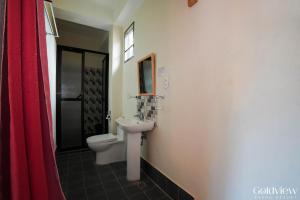 a bathroom with a toilet and a sink at Gold View Beachfront Resort in Timbaon +95 photos