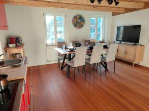 a dining room with a table and chairs and a television at Frutigen 20 nach Interlaken in Frutigen