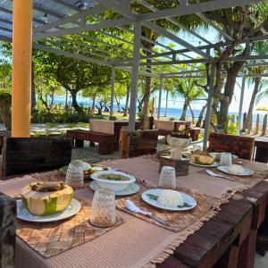 een tafel met daarop borden met eten bij Gold View Beachfront Resort in Timbaon