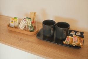 a shelf with two coffee mugs on a tray at Pension am Waldrand in Sinsheim +18 photos
