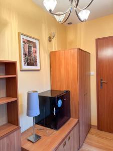 a television on a wooden cabinet in a room at Terra Siciliana in Łęczyca