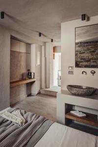 een badkamer met een bed en een wastafel in een kamer bij EJ Boutique Suites in Milína