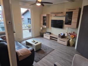 a living room with a couch and a flat screen tv at Ferienwohnung Salza in Nordhausen +15 photos