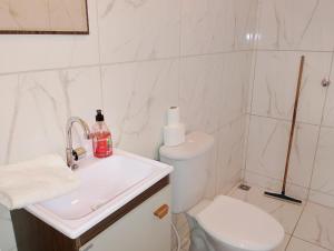 een witte badkamer met een wastafel en een toilet bij Pousada Utopia in Aparecida +6 foto's