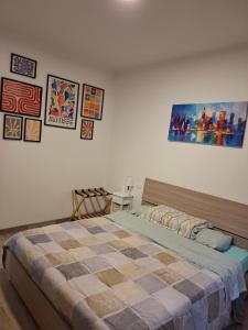 una camera da letto con un letto e alcuni quadri sul muro di Valle Cinque a Fano