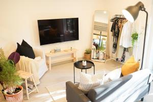 a living room with a couch and a tv on the wall at Tiny home Pana B Private residence 10mins beach in Bophut