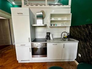 a small kitchen with white cabinets and a sink at Oxford Royal Apartment - Nähe Bahnhof in Bremen +4 photos