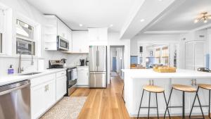 a kitchen with white appliances and wooden floors at 5BR plus Den - Downtown OC - Sleeps 16 in Ocean City