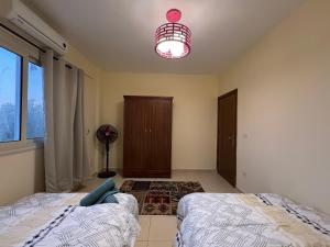 a bedroom with two beds and a light at Zowaar homes in Dahab