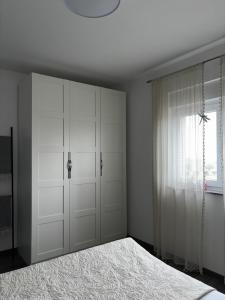 a white bedroom with a bed and a window at Mila in Vodnjan +39 photos
