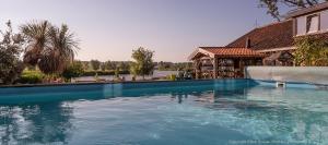 ein großer blauer Swimmingpool vor einem Haus in der Unterkunft Guesthouse Ensenada in Schoondijke