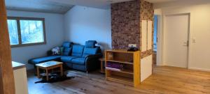 a living room with a blue couch and a brick wall at Daislehof in Münstertal