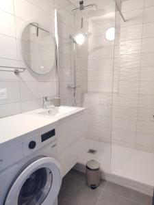 een witte badkamer met een wasmachine en een douche bij Les Hauts de Balaruc- Idéal Curistes 102 in Balaruc-les-Bains