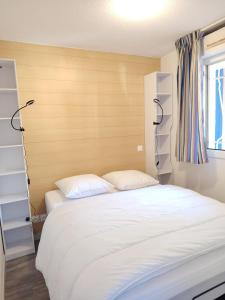 een slaapkamer met een wit bed en een raam bij Les Hauts de Balaruc- Idéal Curistes 102 in Balaruc-les-Bains