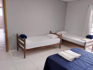 een kamer met 2 bedden en een blauwe tafel bij Pousada Utopia in Aparecida