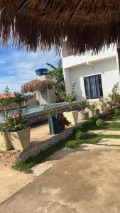a building with a straw umbrella and some plants at Villa carnaúbas in Pedro II +6 photos