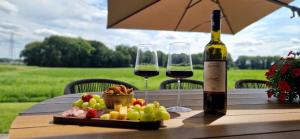 a table with a bottle of wine and a plate of food at Vakantievilla de Broak in Ambt Delden +2 photos