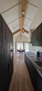 a kitchen with black cabinets and a table in the background at Vakantievilla de Broak in Ambt Delden
