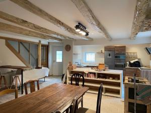a kitchen and dining room with a wooden table at Domaine du plô, Tarn in Trévien
