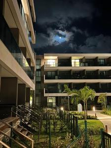 an apartment building at night with the moon in the sky at Flat Premium Muro Alto-conforto a 150m do mar in Ipojuca