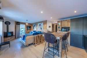 a kitchen and living room with a table and chairs at Le Chalet 138 Megève séjour pour 8 confort espace charme calme in Demi-Quartier