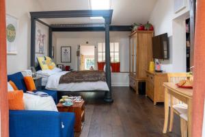 een slaapkamer met een bed en een woonkamer bij Garden Cottage at Old Post Office in Bardon Mill