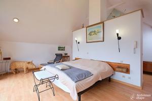 een slaapkamer met een groot bed, een tafel en een stoel bij Gite des étangs de Saint Bale in Vrigne-aux-Bois