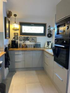 een keuken met witte kasten en een raam bij Gîtes d Izel N1 entre terre et mer prés d'un golf in Ploemel