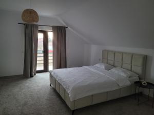 een slaapkamer met een wit bed en een raam bij Casa Nițică in Vaslui