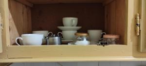 een kast met kopjes en andere spullen op een plank bij Appartement Naim in Tozeur +12 foto's