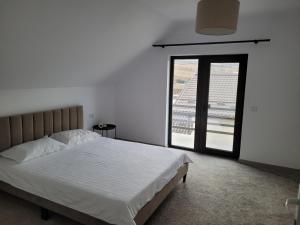 een slaapkamer met een bed en een groot raam bij Casa Nițică in Vaslui +3 foto's