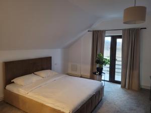 een slaapkamer met een groot bed en een groot raam bij Casa Nițică in Vaslui