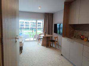 a kitchen and living room with a table and a dining room at Apartament Łukęcin in Łukęcin