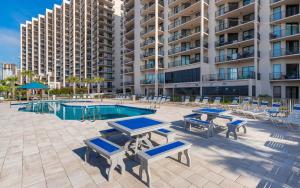 a pool with tables and chairs and a building at Phoenix East II 2032 in Orange Beach