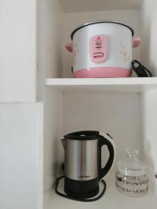 a coffee maker and a pot on a shelf at Silay Haven Near Airport by One Guest Place 3919B in Silay