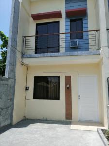 a house with a white garage and a balcony at Silay Haven Near Airport by One Guest Place 3919B in Silay