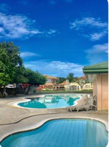 a swimming pool with blue water in a yard at Silay Haven Near Airport by One Guest Place 3919B in Silay