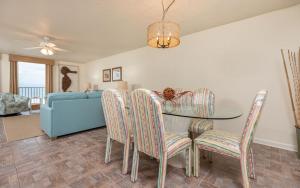 a dining room with a table and chairs and a couch at Phoenix East II 2033 in Orange Beach