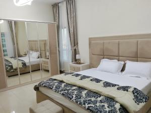 a bedroom with a large bed and a mirror at Orient Tower in Ajman  +17 photos
