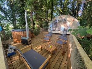 a deck with a igloo and chairs and a grill at Bulle au Fil de l'eau in Romilly-sur-Andelle