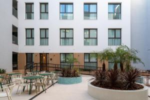 an outdoor patio with tables and chairs in front of a building at Líbere Seville Plaza Nueva in Seville