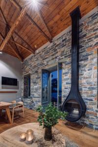 een open haard in een woonkamer met een stenen muur bij EJ Boutique Suites in Milína +53 foto's