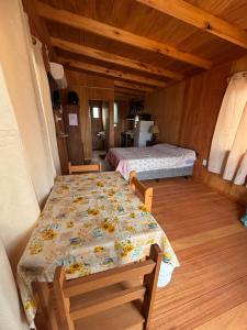 a room with two beds and a table and chairs at La pinta roja in Punta Del Diablo
