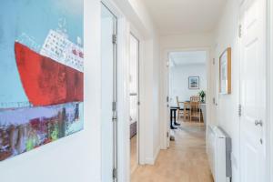 a hallway with white walls and a large painting on the wall at 3 Bed in Waren Mill oc-gd1928 in Bamburgh