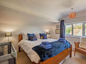 una camera da letto con un letto con asciugamani blu sopra di 5 Bed in Dorchester oc-86025 a Winfrith Newburgh