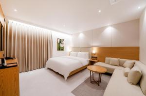 a hotel room with a bed and a couch at Daisy hotel in Tongyeong +54 photos