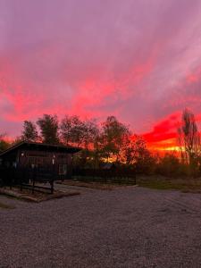 einen Sonnenuntergang mit einem Gebäude und einem roten Himmel in der Unterkunft Tiny House Detrás del río in Colbún